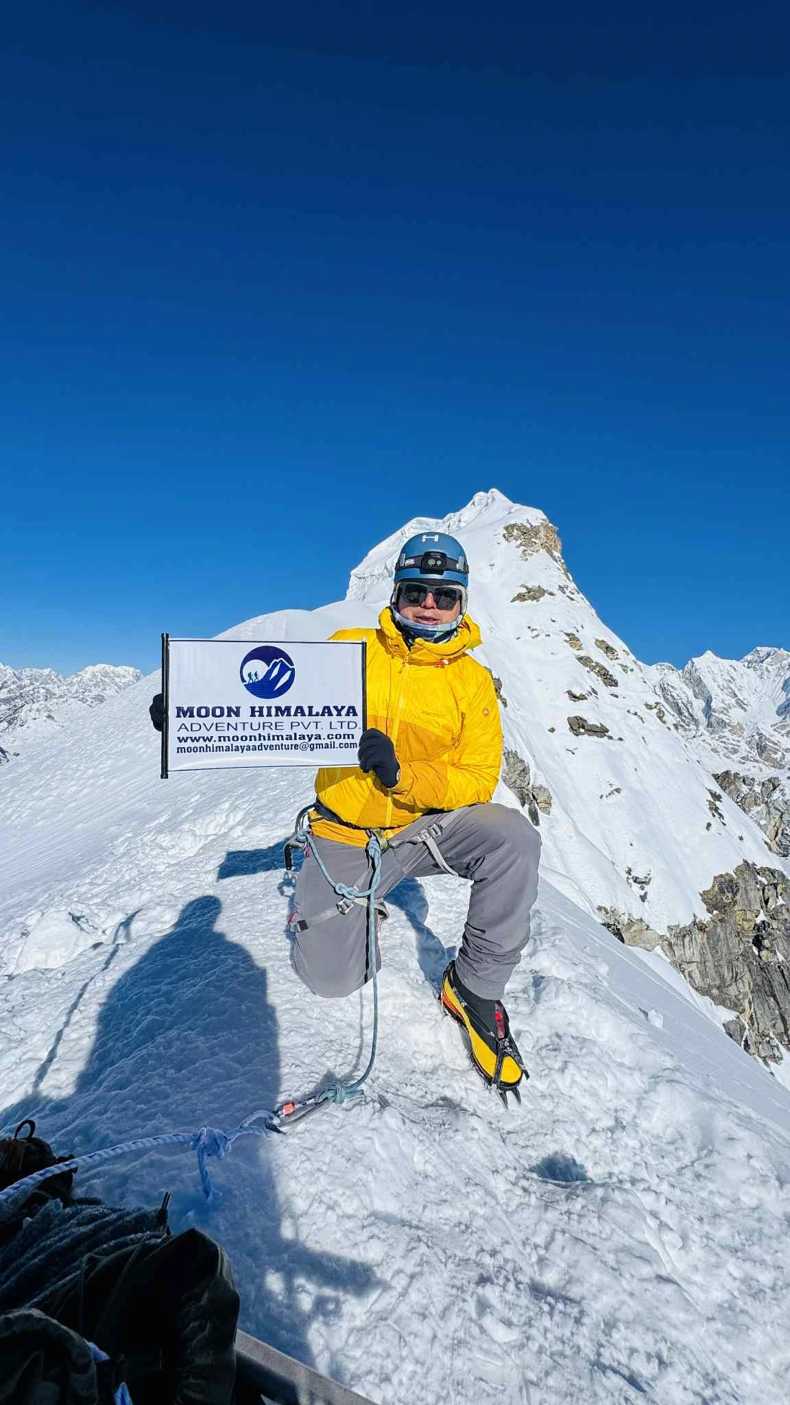 Lachhuman Tamang at Lobuche Peak summit holding Moon Himalaya Adventure banner in Nepal Himalayas